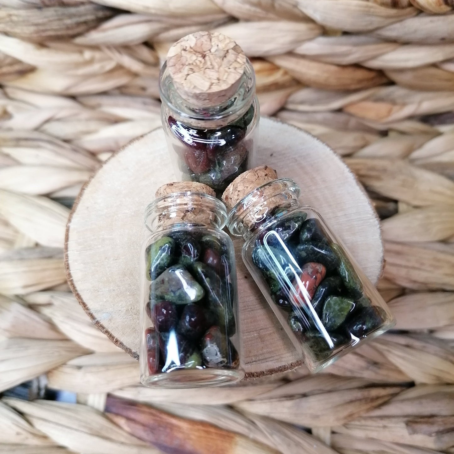 green red and black dragonstone crystal chips in a clear glass bottle