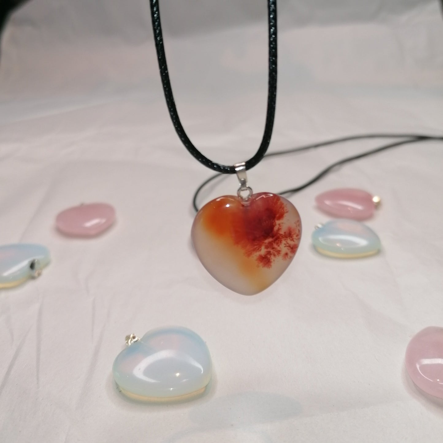 red carnelian heart shaped crystal necklace on a black chord chain