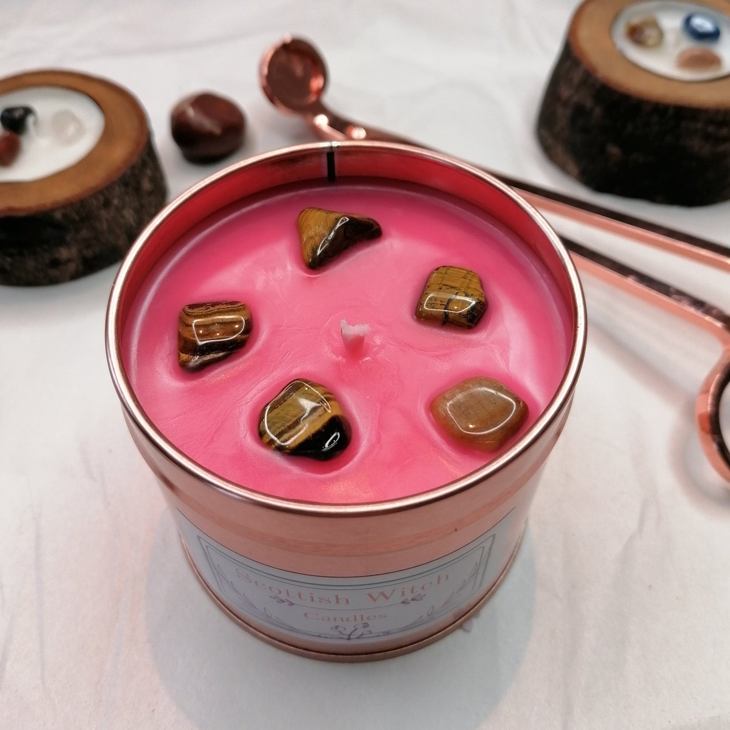 pink candle in a rose gold tin decorated with tigers eye crystal chips