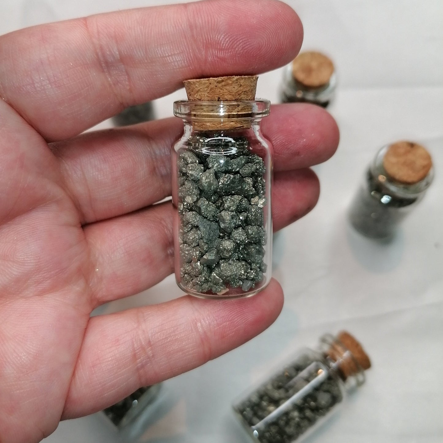 small glass bottle containing small pyrite fools gold chips