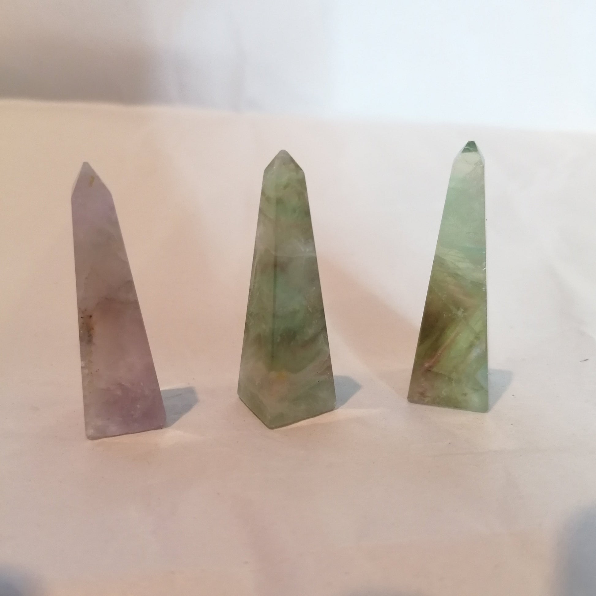 three purple and green fluorite obelisk towers