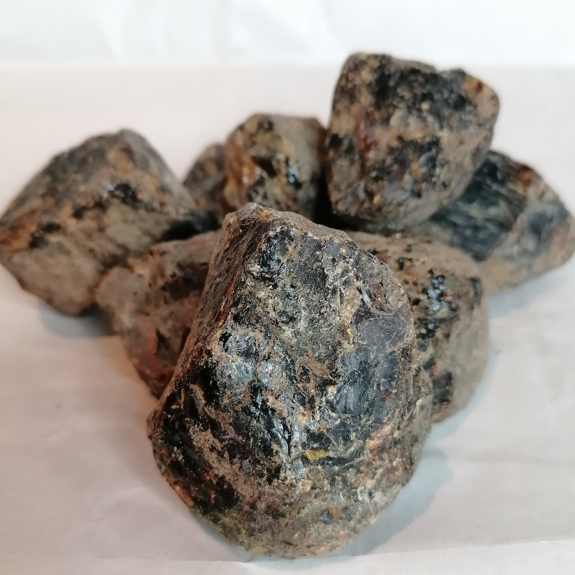 close up picture of raw black amber chunks in a pile