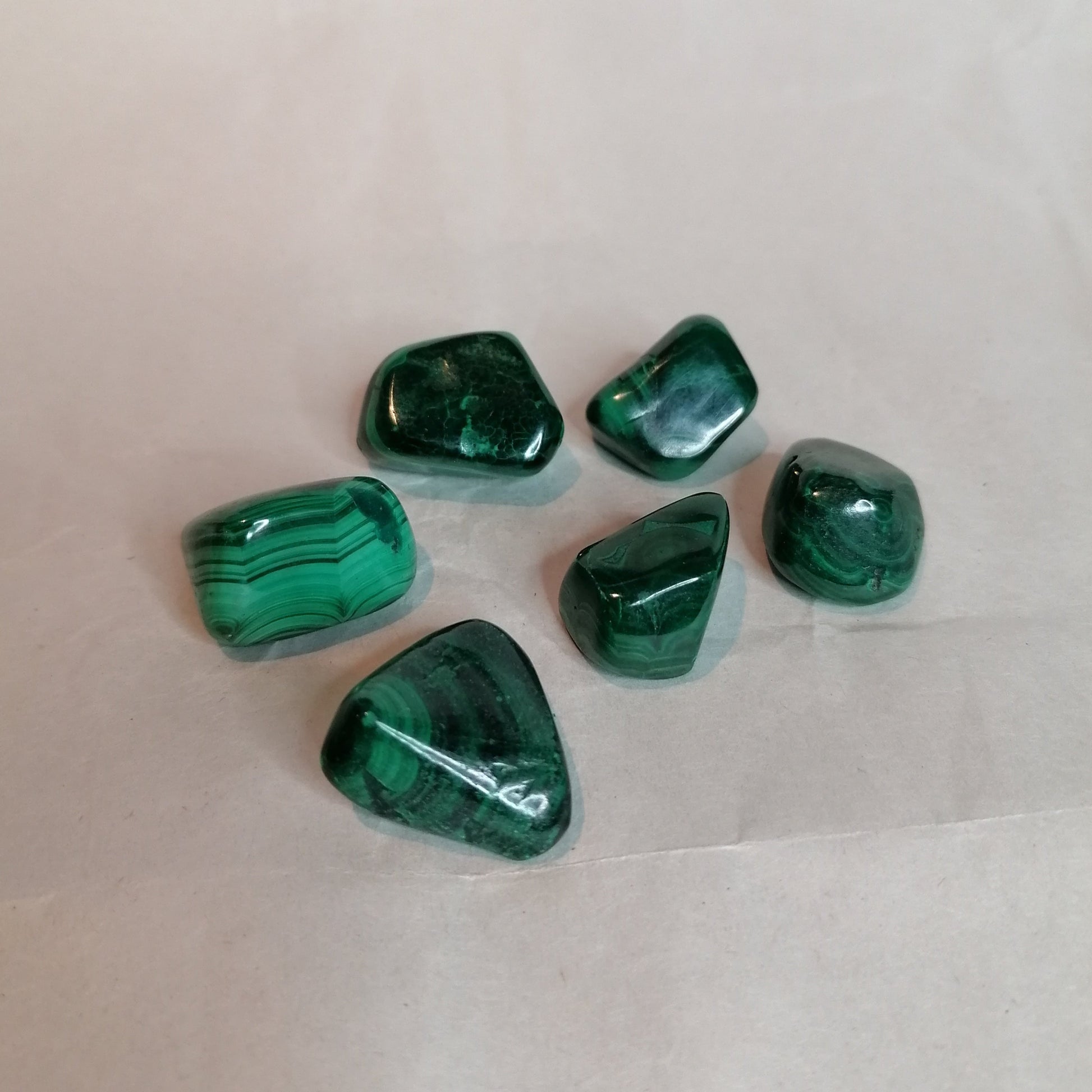 picture of 6 malachite crystals with all different shades of green and pattern