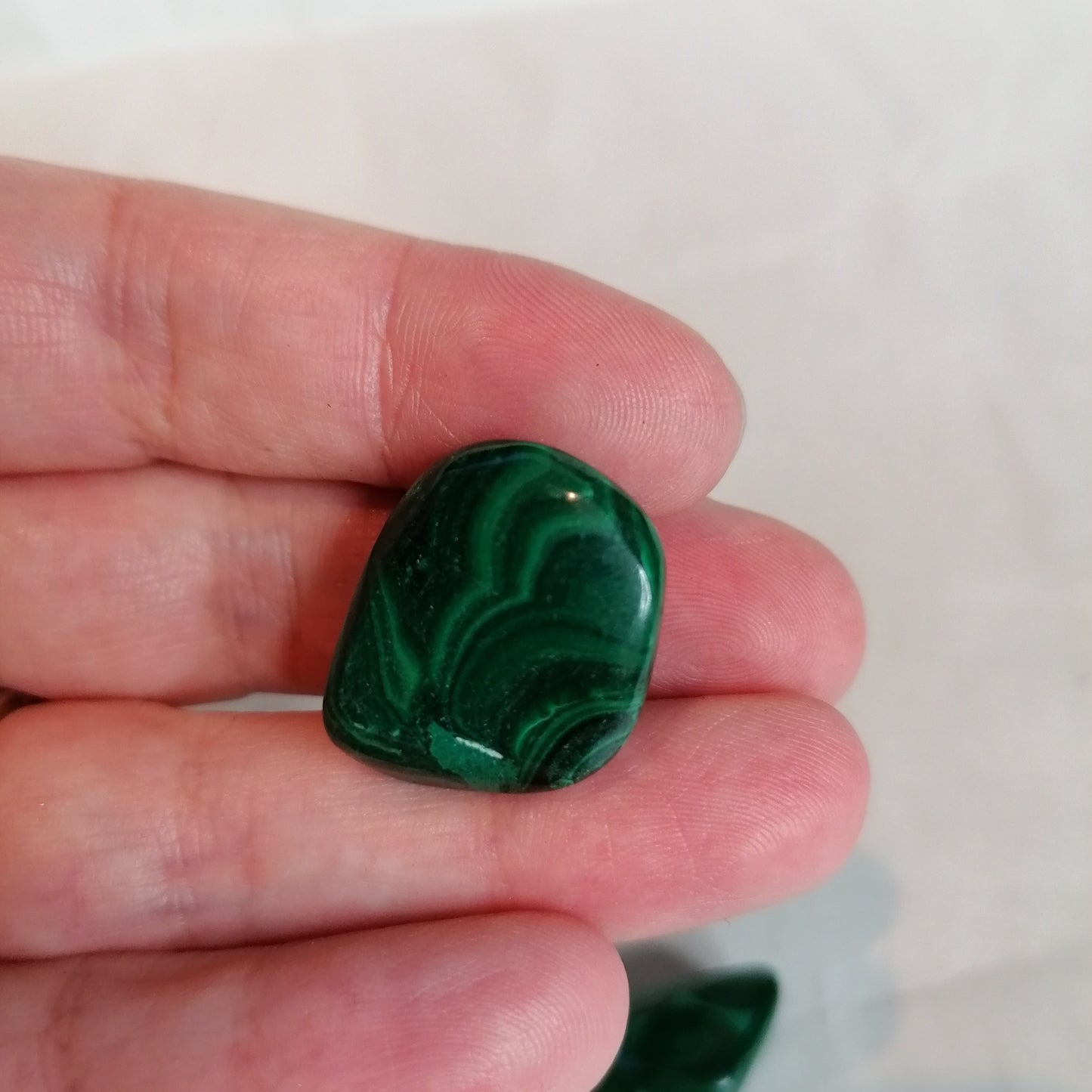 A close up of a green malachite crystal with spiral pattern