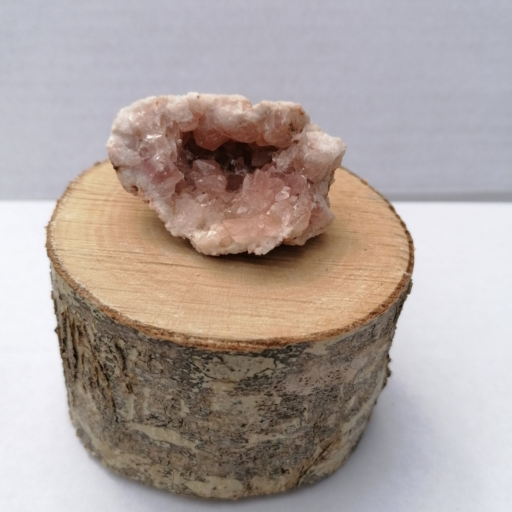 rare top quality pink amethyst geode on a wooden display