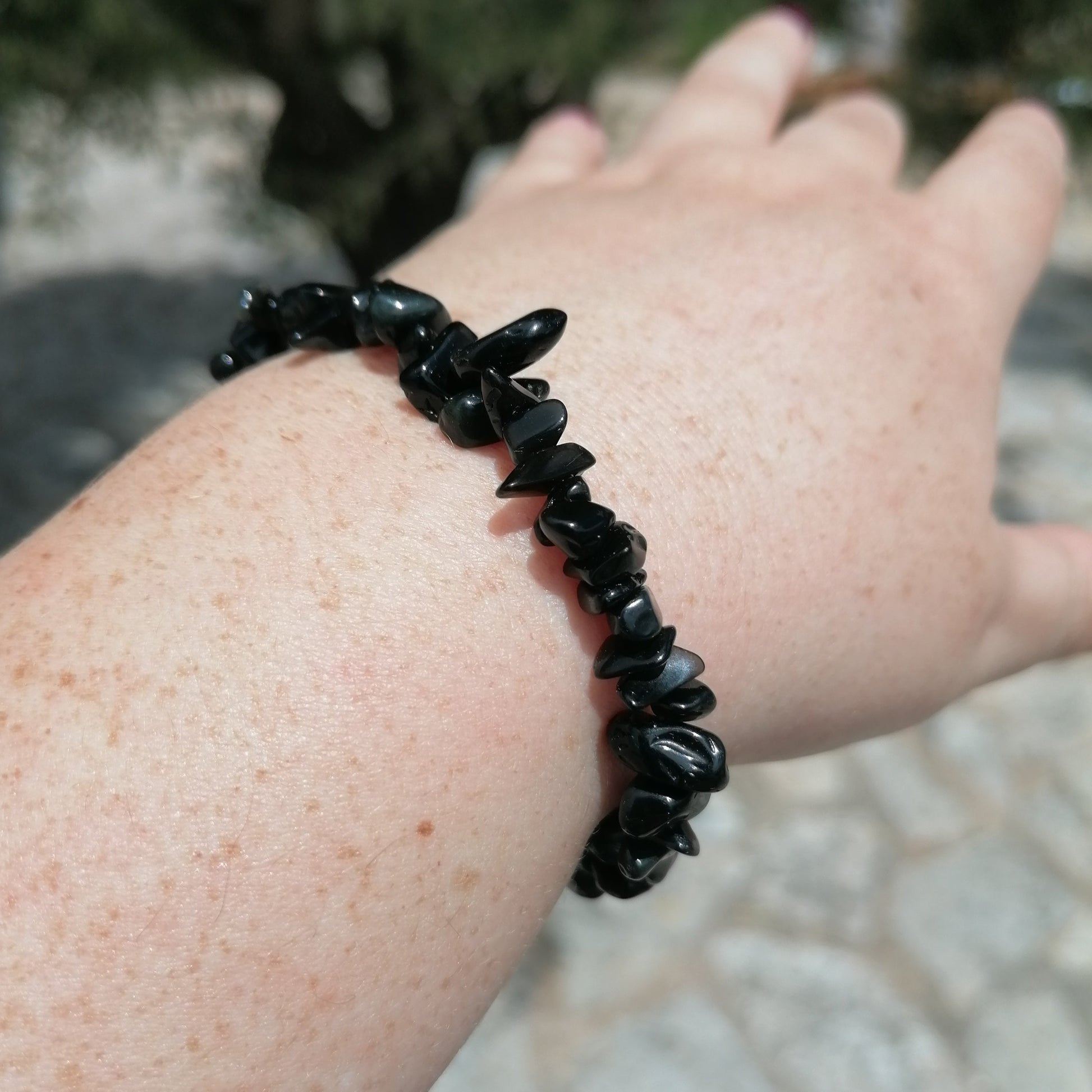 a black obsidian chip bracelet on a wrist