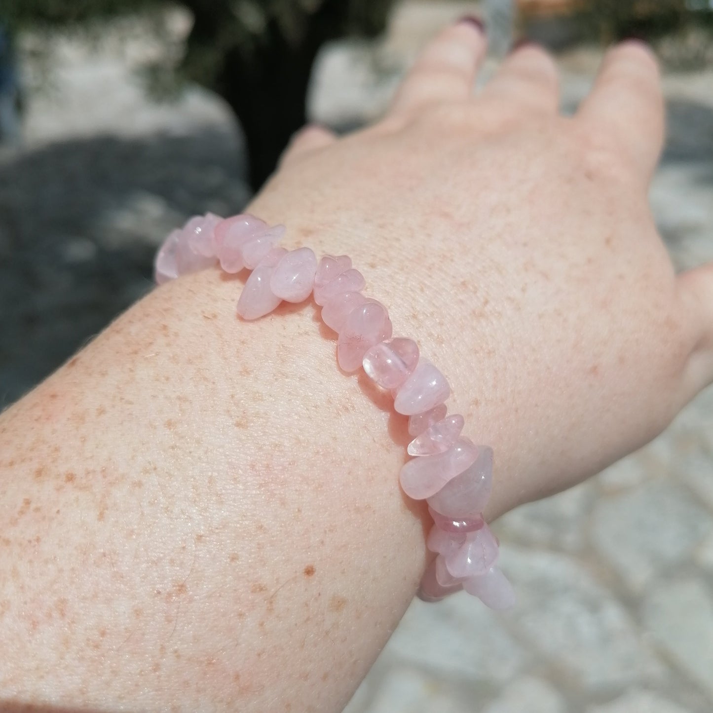 pink rose quartz crystal chip bracelet on wrist