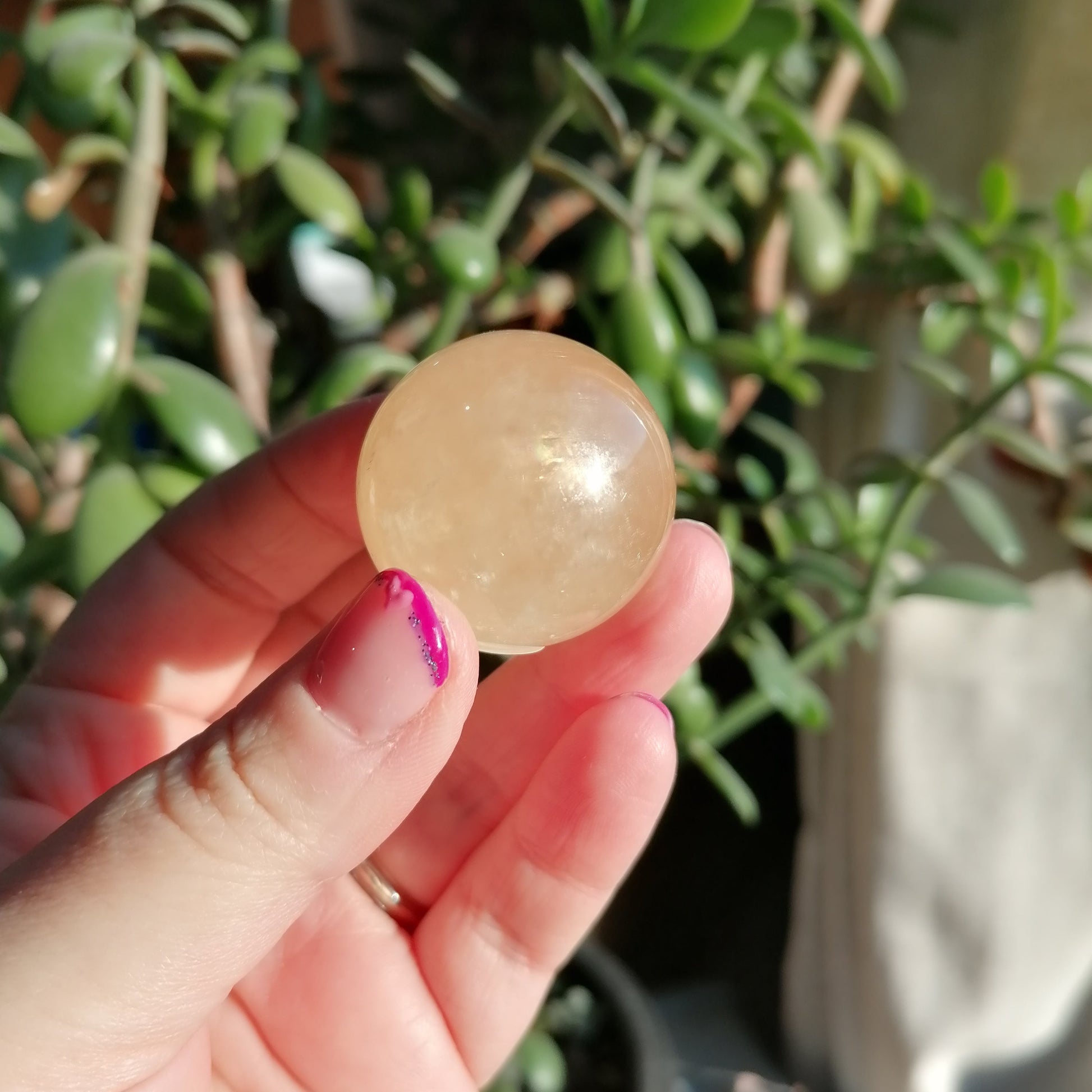 white optical honey calcite sphere with rainbows, flashes and asterisms