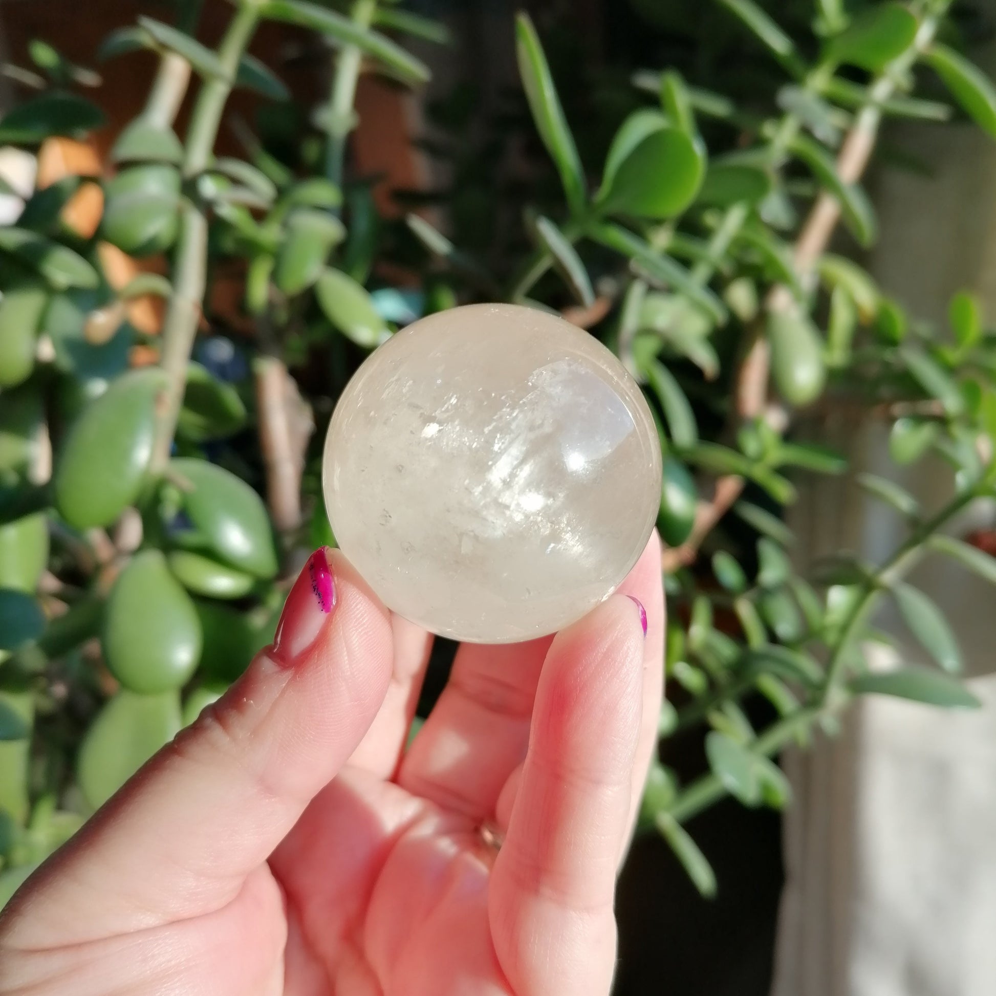 White honey optical honey calcite sphere with asterisms, flashes and rainbows