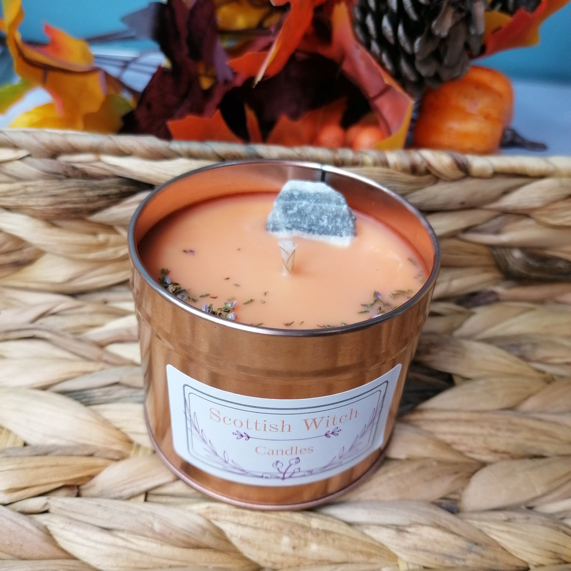 an orange candle decorated with a zebra calcite crystal and scottish heather scented with a lovely salted caramel sweet scent