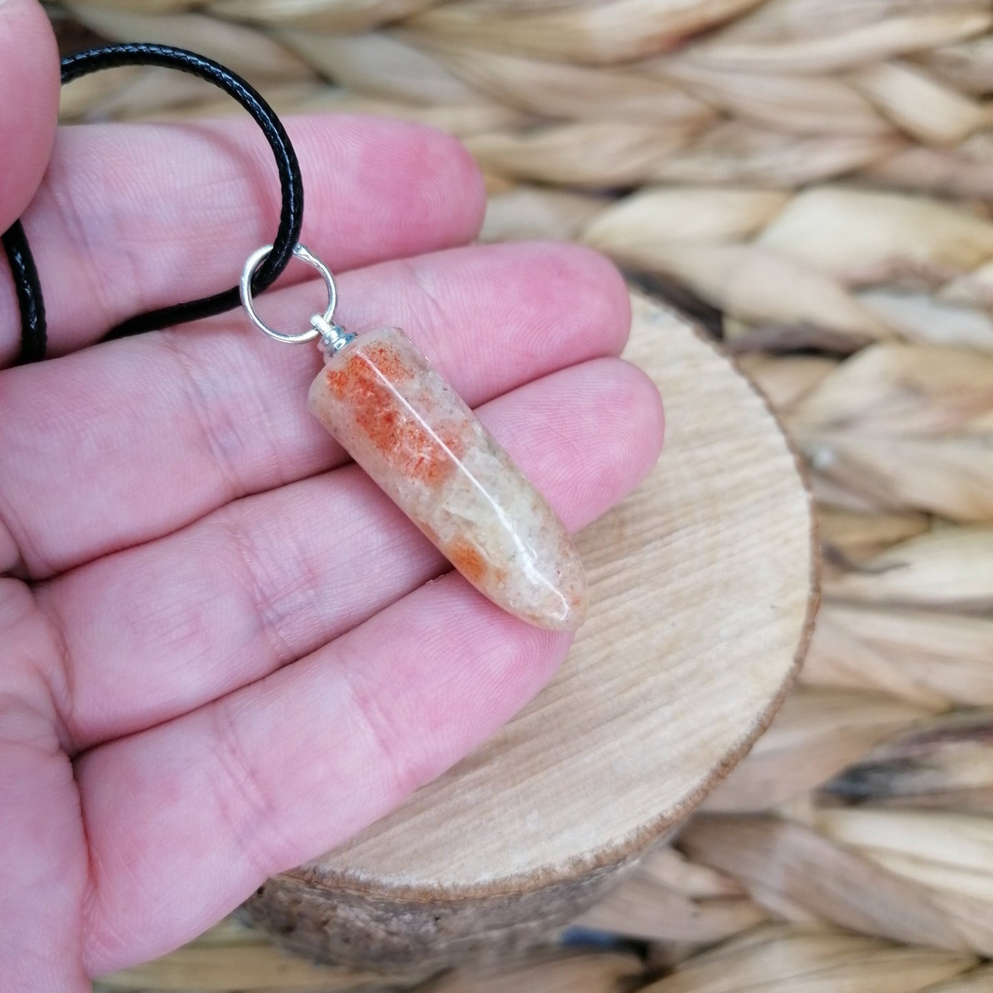 Orange and white sunstone with orange glittery flash bullet point necklace on a black chord chain