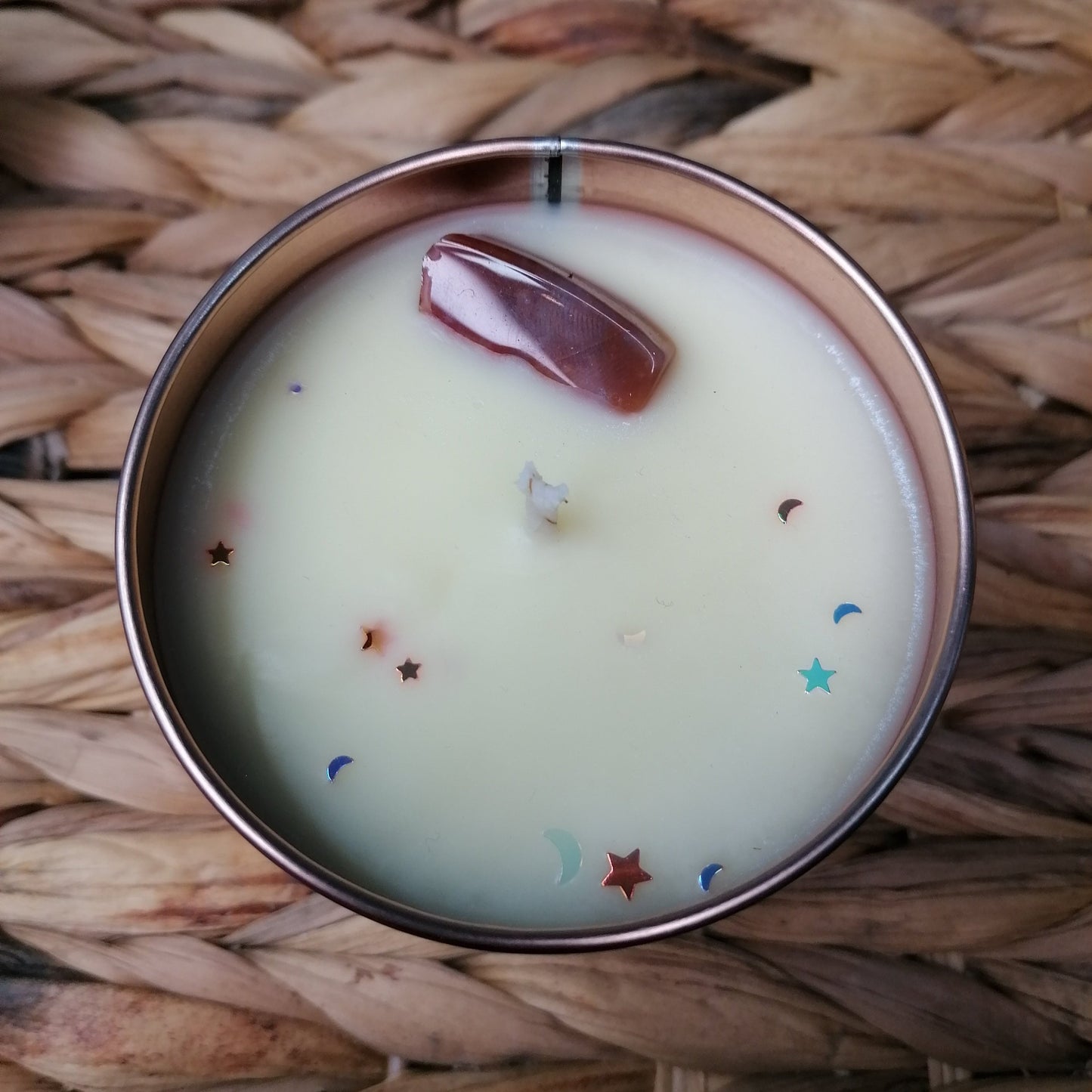 white candle with a fresh linen scent in a rose gold tin decorated with a jasper crystal and glitter