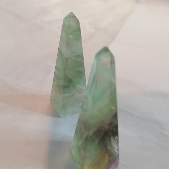 short video of all sides of the green and purple fluorite obelisk towers and a ring going on at the end to show that it makes a good ring holder