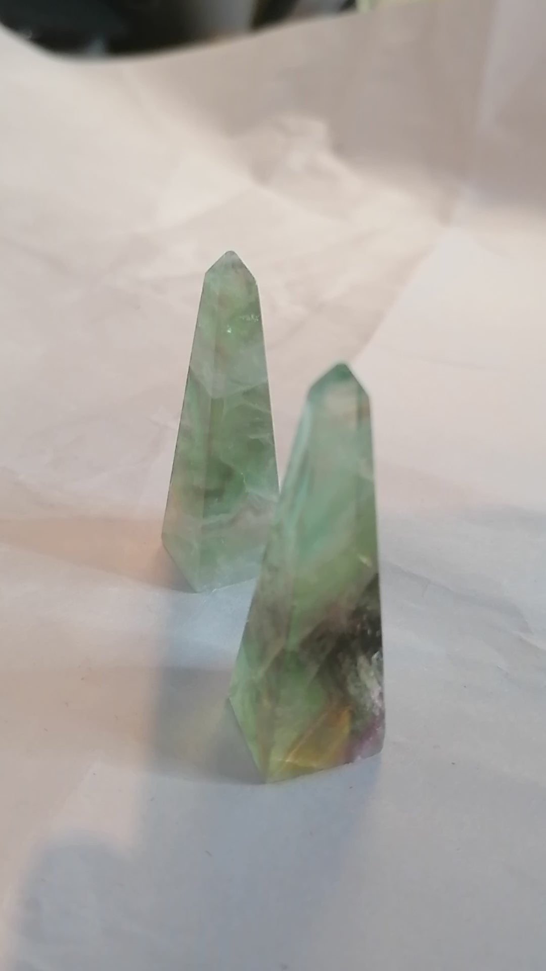 short video of all sides of the green and purple fluorite obelisk towers and a ring going on at the end to show that it makes a good ring holder