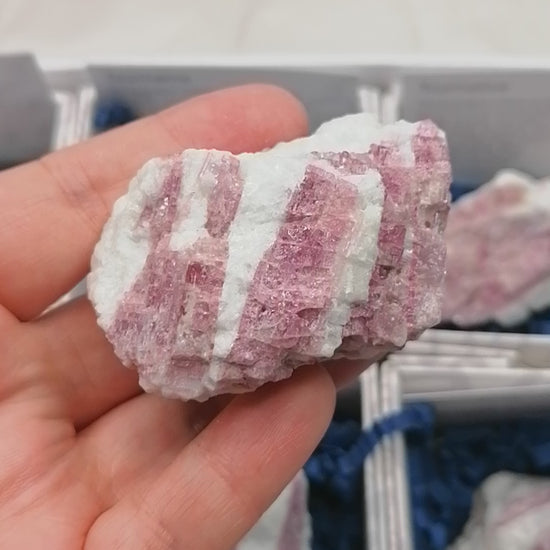 video of a piece of raw pink tourmaline set in white quartz