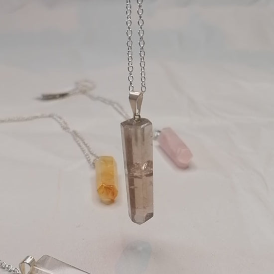 smokey quartz crystal point necklace on silver chain moving in the light