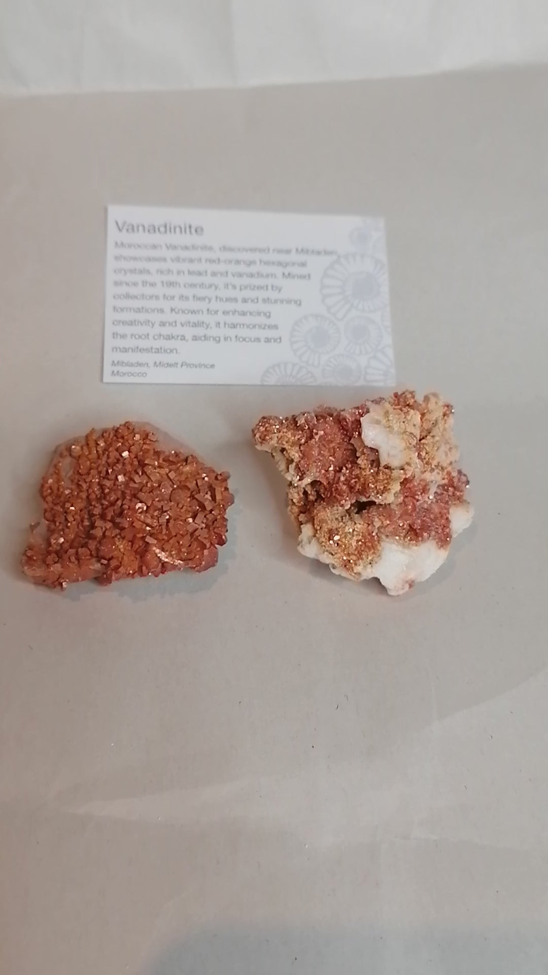 a short video bright orange square crystals on a cream rock formation, vanadinite crystal specimen