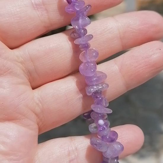 a dark purple amethyst crystal chip bracelet being rotated so you can see all the crystals