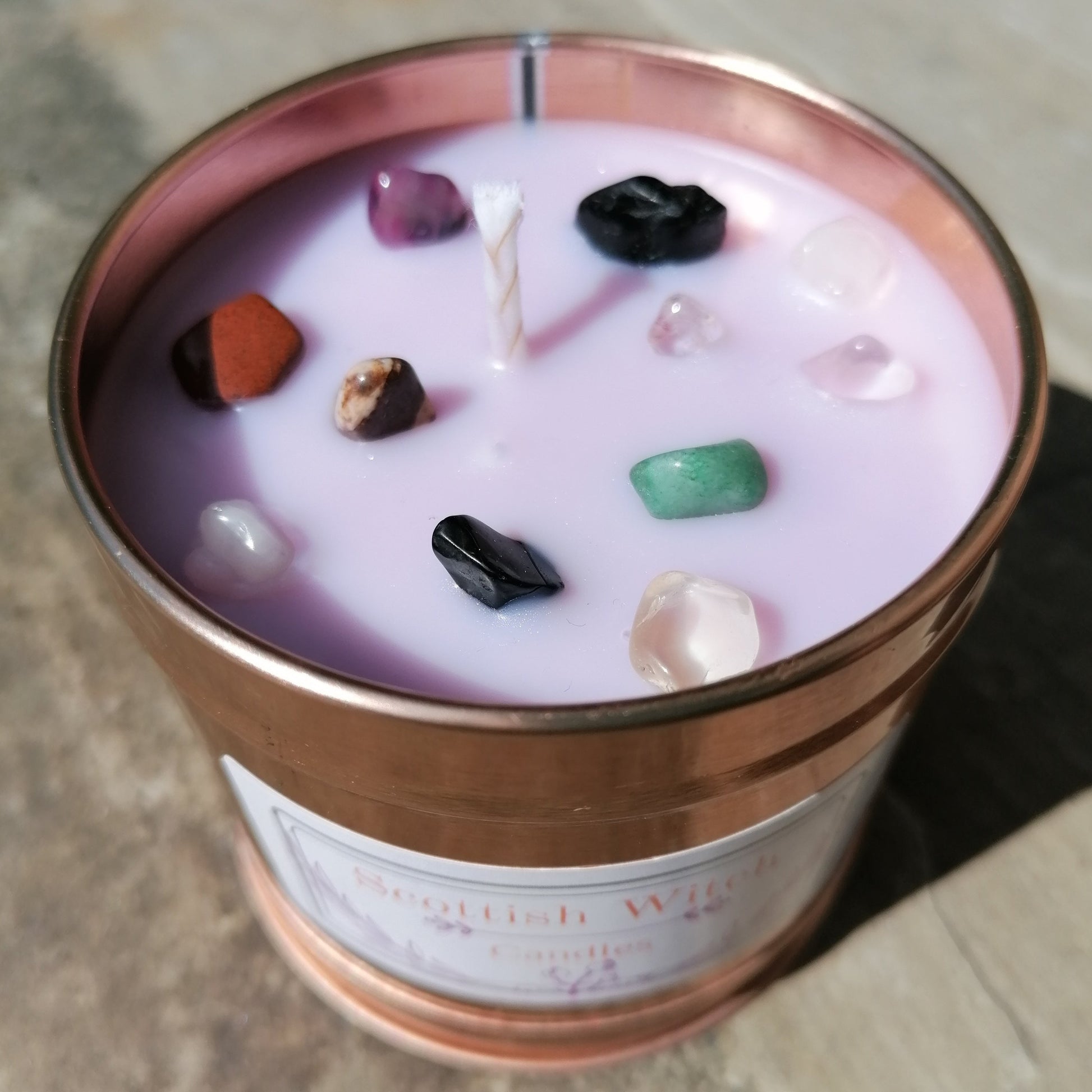 purple candle in a rose gold tin decorated with mixed colour crystal chips