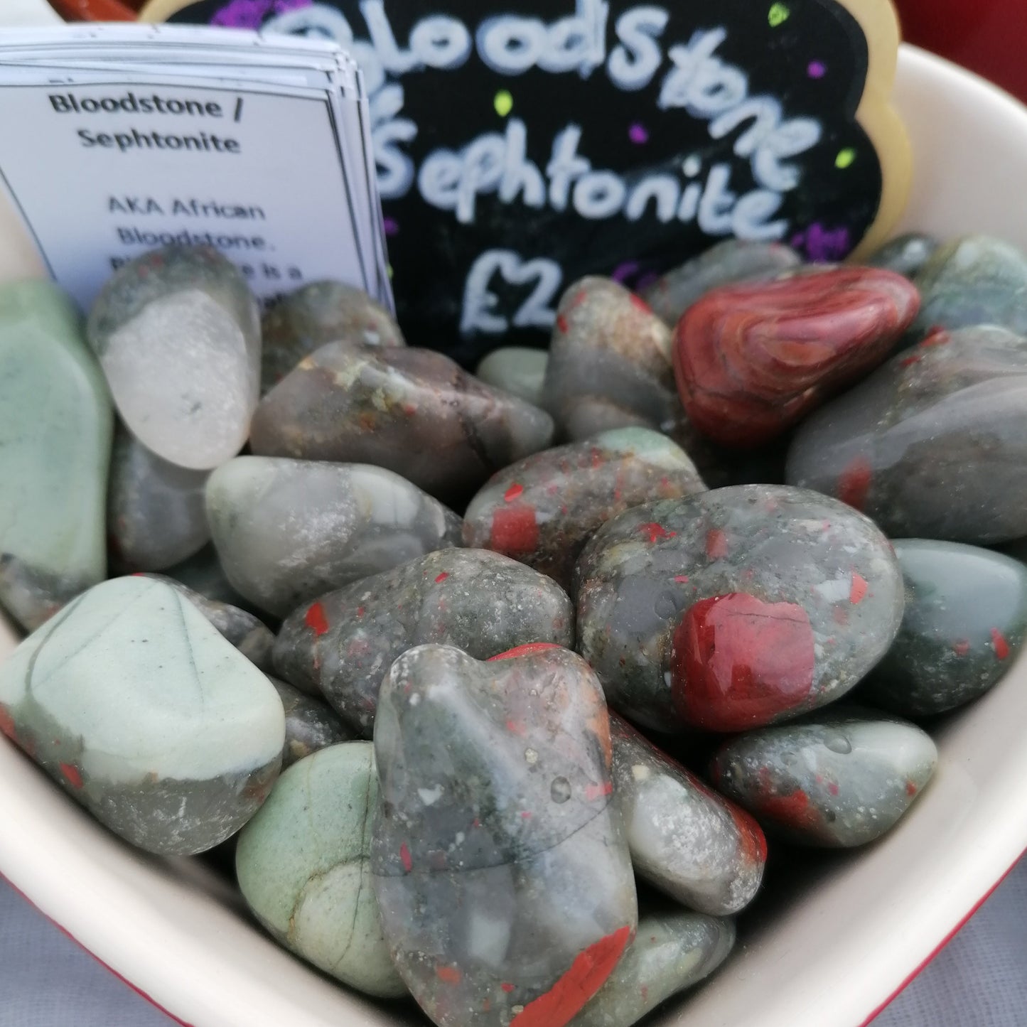 a dish of green and red spotted bloodstone tumbles