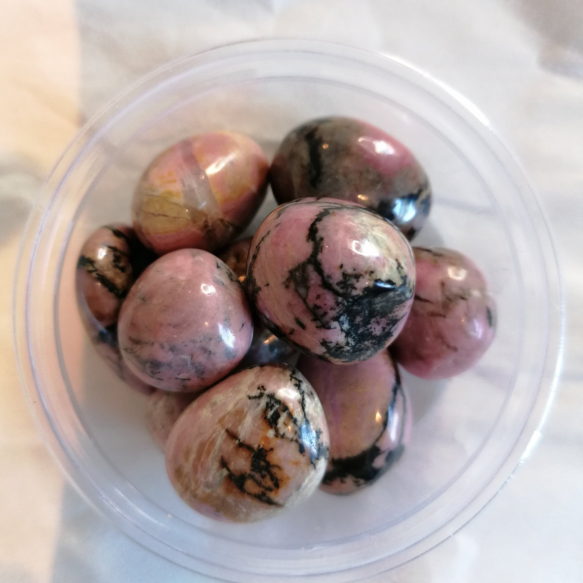 Pink and black rhodonite tumbles