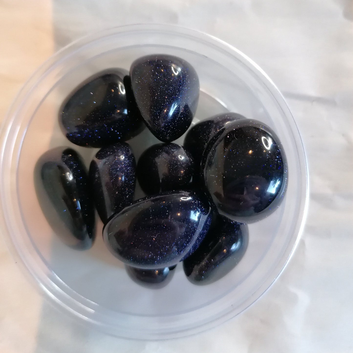 a dish of blue sparkly goldstone crystal tumbles