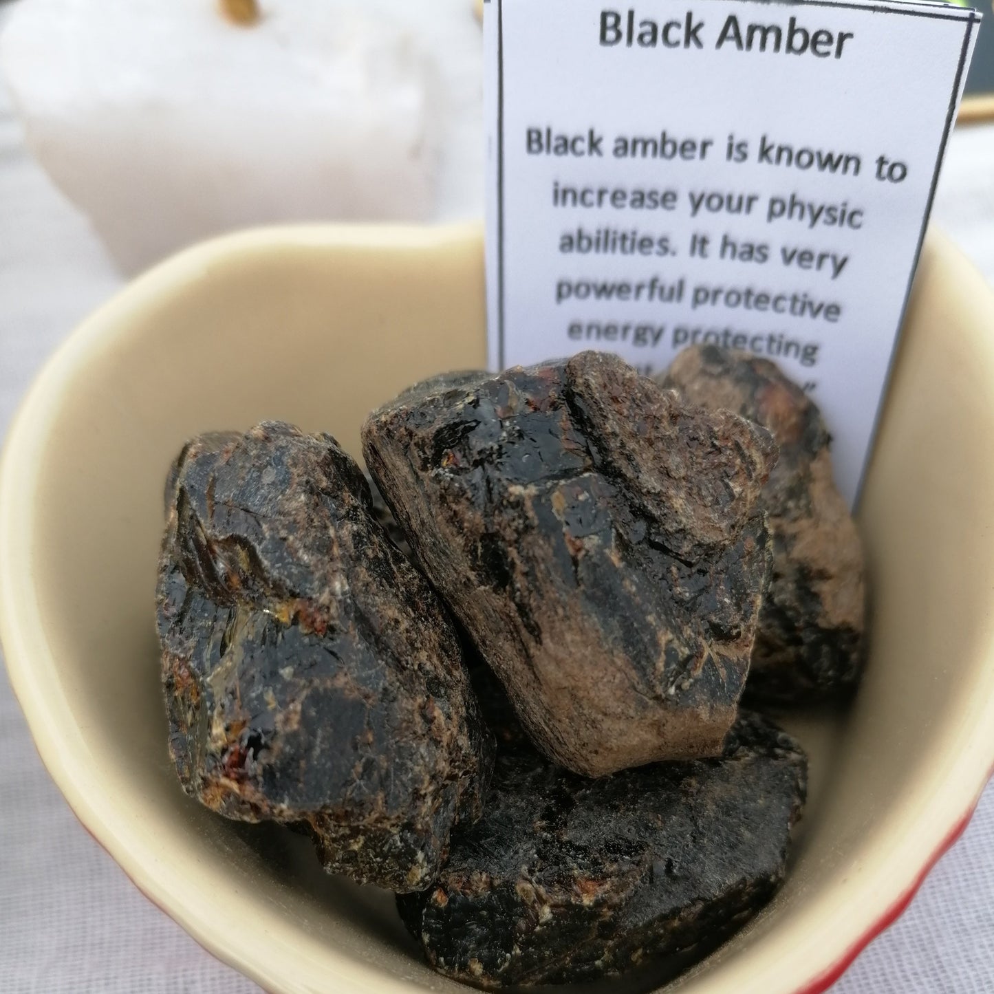 A dish of raw black amber chunks with description cards