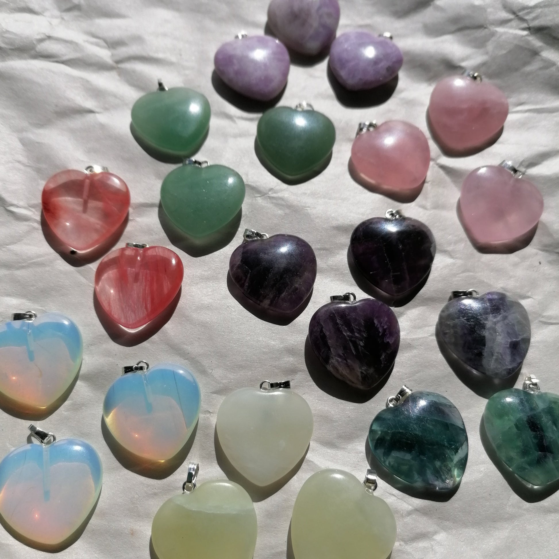 a colourful selection of crystal heart necklaces