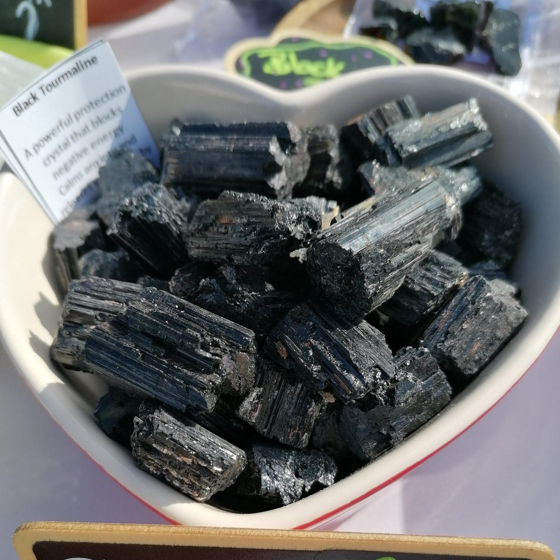 a dish of black tourmaline chunks with description cards