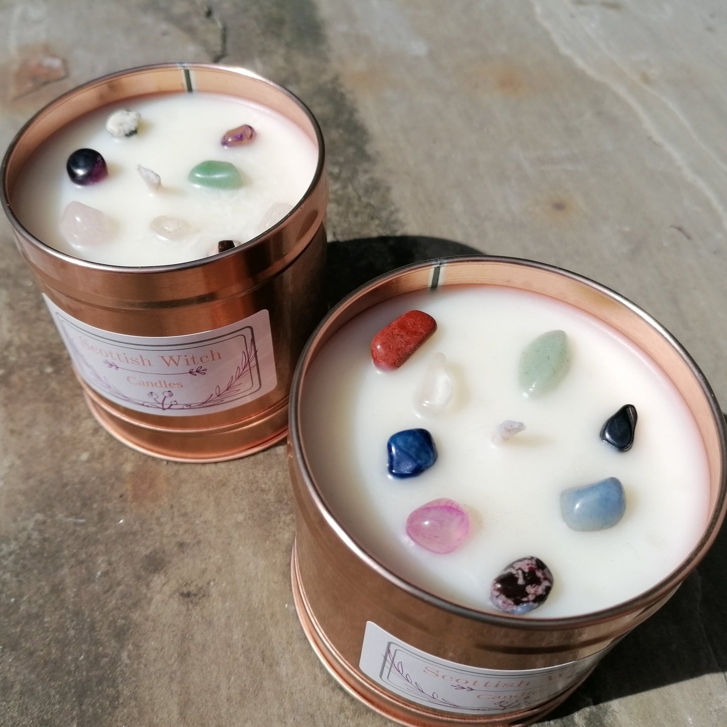 two white candle in rose gold tins decorated with mixed colour crystal chips