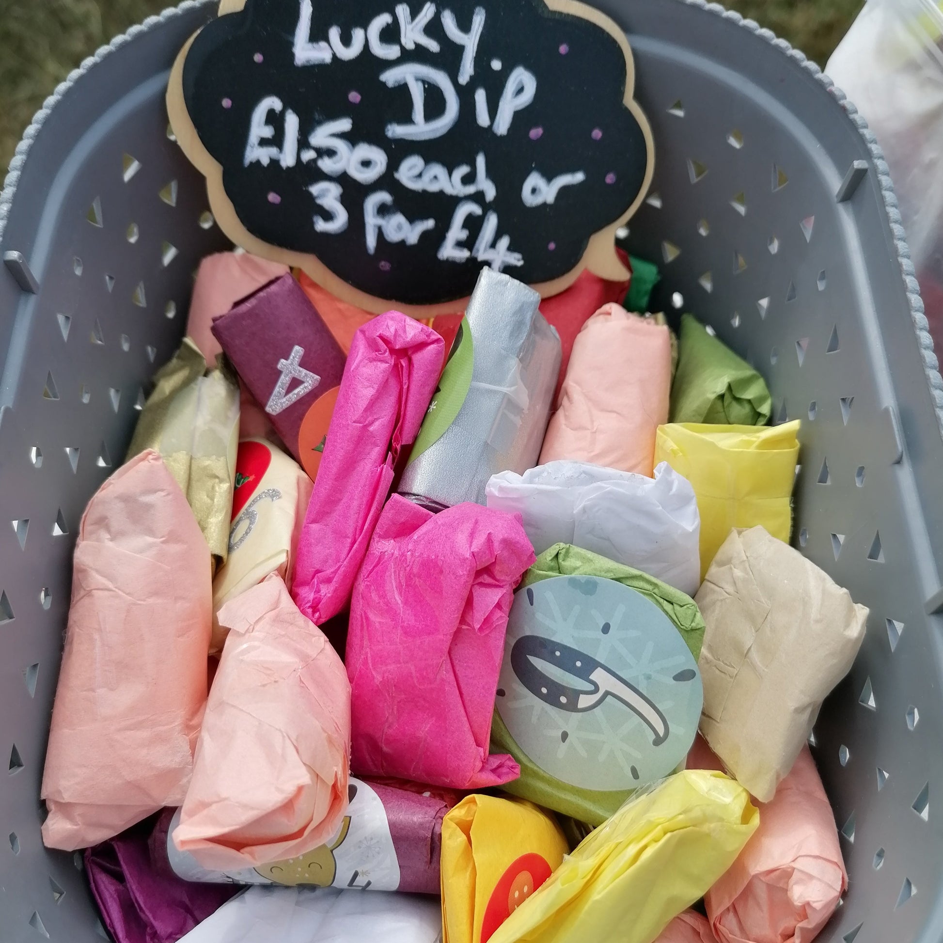 box of colourful tissue wrapped lucky dip parcels