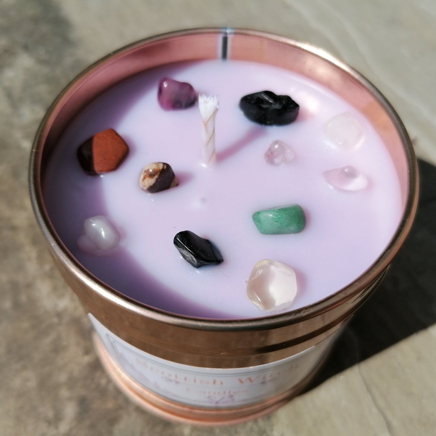 purple candle in a rose gold tin decorated with mixed colour crystal chips