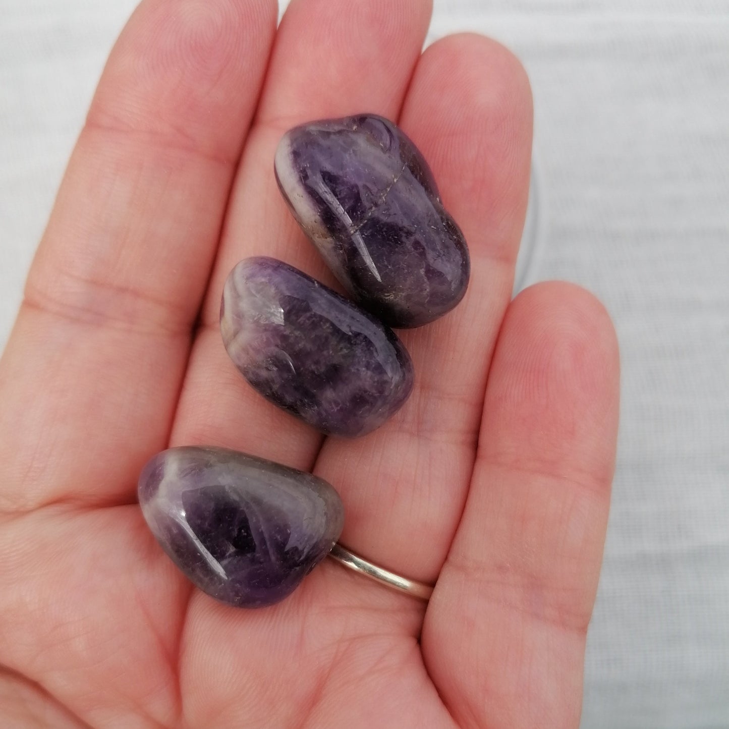 three small dark purple amethyst tumblestones