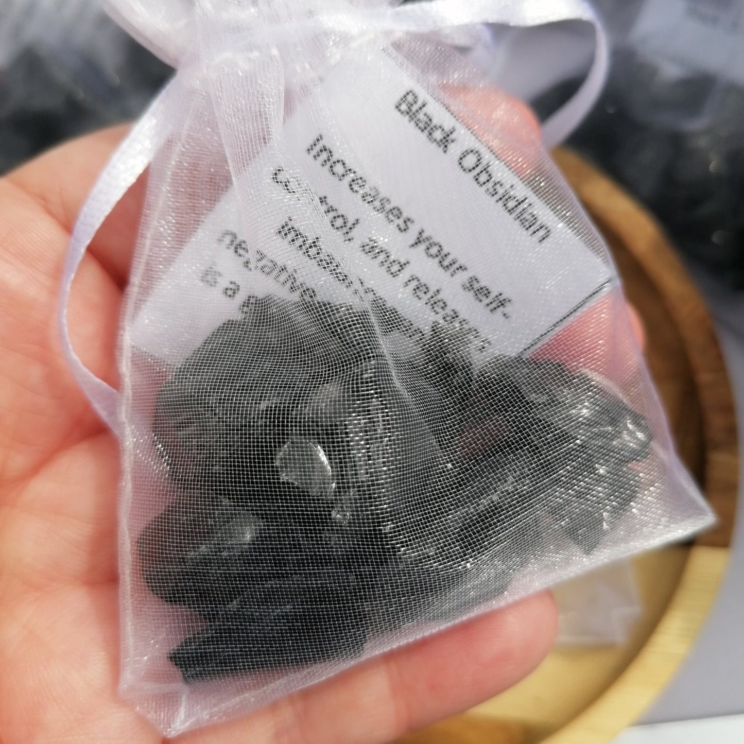 an organza bag full of raw black obsidian chunks